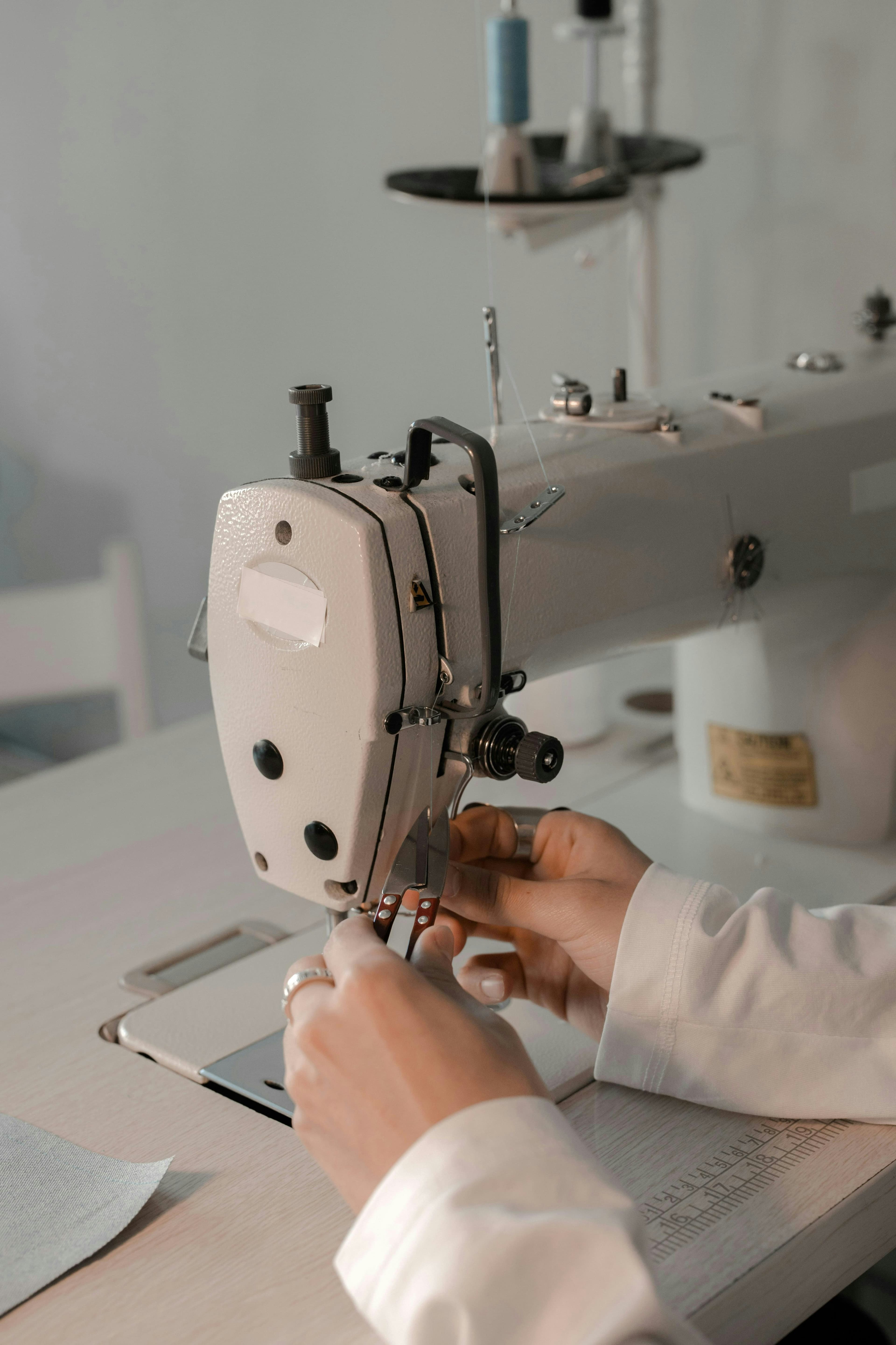 A sewist guiding fabric through an industrial sewing machine